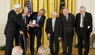 FILE - In this Nov. 15, 2007 file photo, President Bush, third from left, presents the 2007 National Humanities Medal to members of the Monuments Men Foundation, from left, Robert Edsel, Jim Reeds, Harry Ettlinger, Horace Apgar and Seymore Pomrenze, for the Preservation of Art of Dallas, Texas, during a ceremony at the White House in Washington. White House ceremonies for arts and science medal winners, a tradition dating back to the 1980s, have been absent so far in the Trump administration. Eighteen months into Trump’s presidency, there have been no National Science Medals, or National Medals of Arts or National Medals of Humanities.  (AP Photo/Gerald Herbert, File)