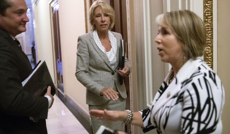 Education Secretary Betsy DeVos, center, has a final word with Hispanic Caucus Chair Rep. Michelle Lujan Grisham, D-N.M., right, following a meeting on Capitol Hill in Washington, Thursday, July 26, 2018. (AP Photo/J. Scott Applewhite)