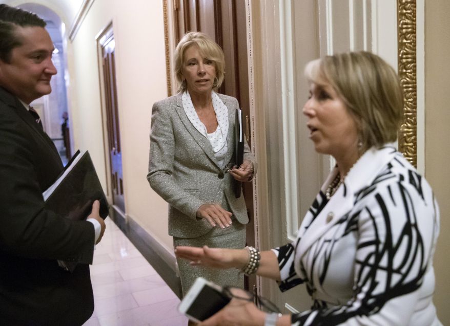 Education Secretary Betsy DeVos, center, has a final word with Hispanic Caucus Chair Rep. Michelle Lujan Grisham, D-N.M., right, following a meeting on Capitol Hill in Washington, Thursday, July 26, 2018. (AP Photo/J. Scott Applewhite)