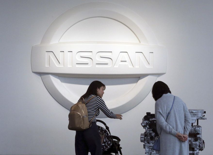 In this Nov. 10, 2017, file photo, visitors walk around a gallery of the Nissan Motor Co. at its global headquarters in Yokohama, near Tokyo. Nissan Motor Co. says its profits plunged 14 percent in the latest quarter as U.S. and European sales fell sharply and raw material costs rose. (AP Photo/Koji Sasahara, file)
