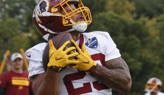 Washington Redskins running back Derrius Guice (29) hauls in a pass during NFL football training camp in Richmond, Va., Thursday, July 26, 2018. (AP Photo/Steve Helber)