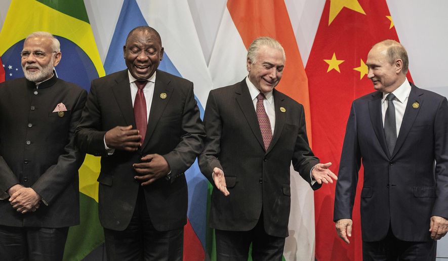 From left, Indian Prime Minister Narendra Modi, South African President Cyril Ramaphosa, Brazil's President Michel Temer and Russia's President Vladimir Putin, get ready for a group photo at the BRICS Summit in Johannesburg, South Africa, Thursday, July 26, 2018. Putin arrived in South Africa Thursday, the last head of state to arrive for the Summit. (Gianluigi Guerci/Pool Photo via AP)