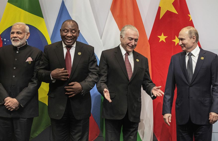 From left, Indian Prime Minister Narendra Modi, South African President Cyril Ramaphosa, Brazil's President Michel Temer and Russia's President Vladimir Putin, get ready for a group photo at the BRICS Summit in Johannesburg, South Africa, Thursday, July 26, 2018. Putin arrived in South Africa Thursday, the last head of state to arrive for the Summit. (Gianluigi Guerci/Pool Photo via AP)