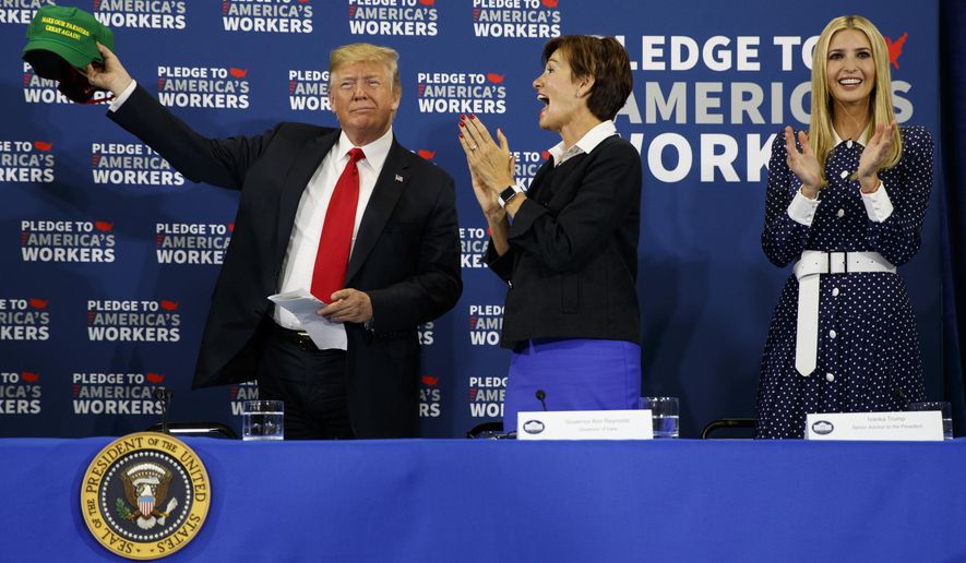 Ivanka Trump, right, and Gov. Kim Reynolds, R-Iowa, center, look on as President Donald Trump holds up a &amp;quot;Make Our Farmers Great Again&amp;quot; hat during a roundtable discussion on workforce development at Northeast Iowa Community College, Thursday, July 26, 2018, in Peosta, Iowa. (AP Photo/Evan Vucci)