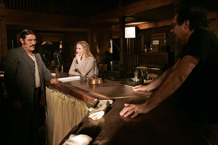 FILE - This Feb. 9, 2005 file photo shows actors Ian McShane, who portrays Al Swearengen, left, and Paula Malcomson, who portrays Trixie, center, on the set with David Milch, creator of the HBO series "Deadwood," in Santa Clarita, Calif. HBO says it's greenlighted a long-discussed movie based on the Western drama that ended a dozen years ago. The critically acclaimed, award-winning series was set in the rough-and-tumble South Dakota mining town of the title. (AP Photo/Kevork Djansezian, File)
