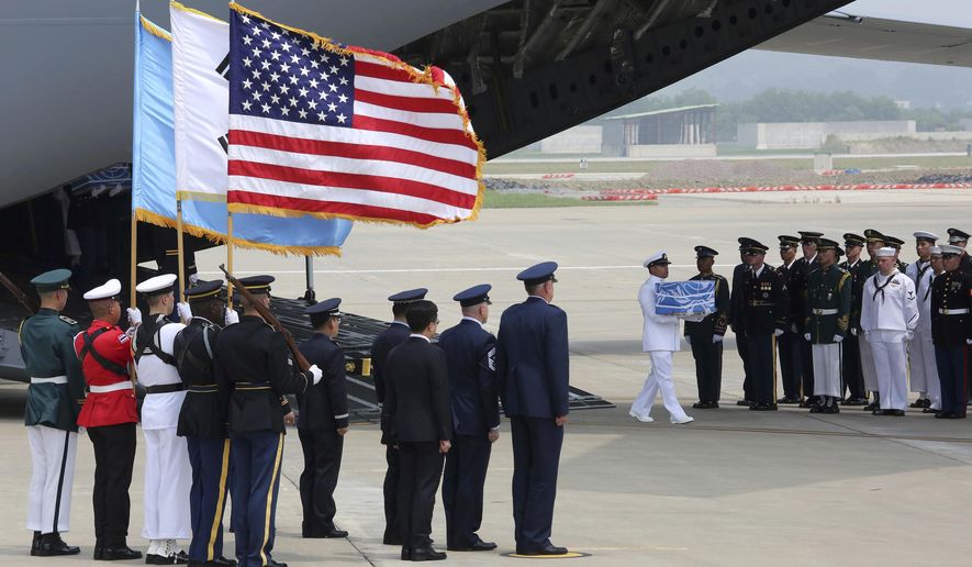 A U.N. honor guard carries a casket containing remains believed to be from American servicemen killed during the 1950-53 Korean War after arriving from North Korea, at Osan Air Base in Pyeongtaek, South Korea, Friday, July 27, 2018. The U.N. Command says the 55 cases of war remains retrieved from North Korea will be honored at a ceremony next Wednesday at a base in South Korea. (AP Photo/Ahn Young-joon, Pool)