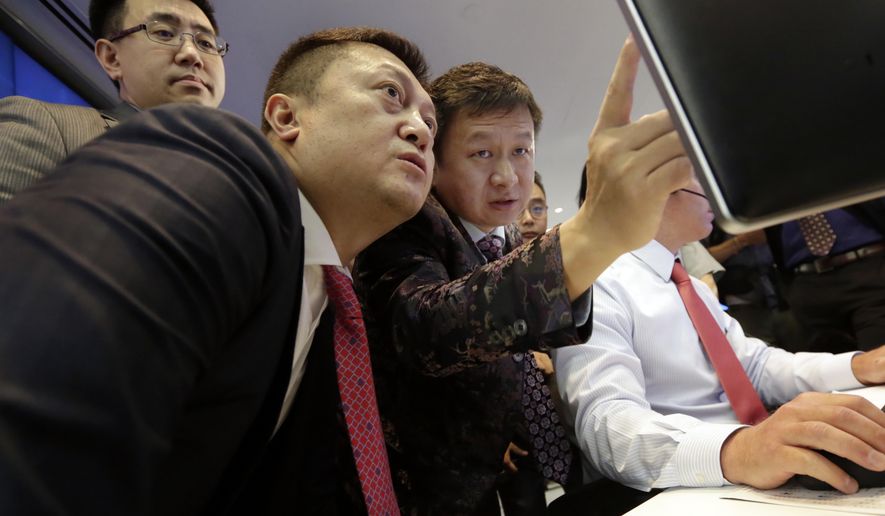 Opera Limited Chairman & CEO Yahui Zhou, third left, with secretary to the board An Da, left, and Shu Guan Wang, from China International Capital Corp., watch price quotes before Opera's IPO begins trading, at the Nasdaq MarketSite, in New York's Times Square, Friday, July 27, 2018. (AP Photo/Richard Drew)