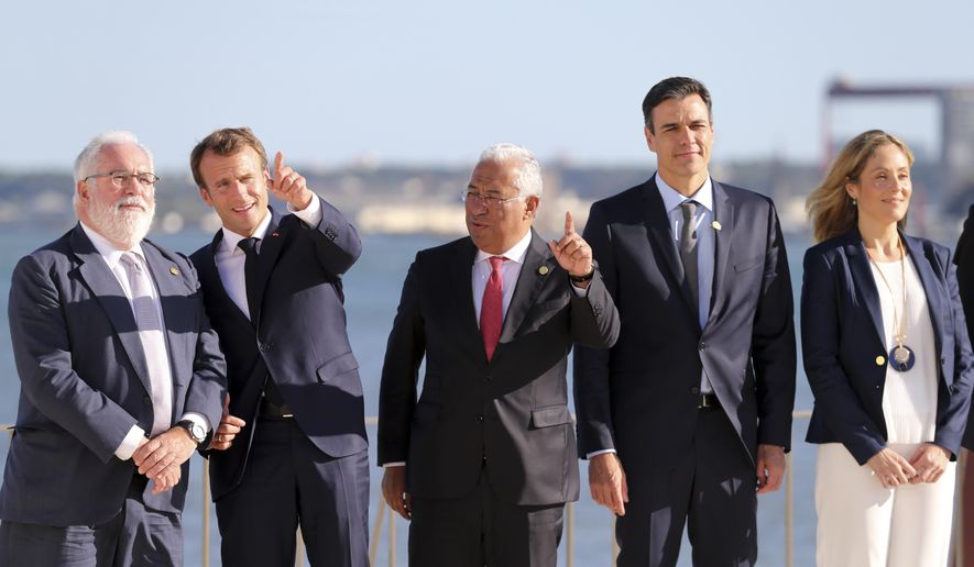 EU Climate Action and Energy Commissioner Miguel Arias Canete, French President Emmanuel Macron, Portuguese Prime Minister Antonio Costa, Spanish Prime Minister Pedro Sanchez and Vice President of European Investment Bank Emma Navarro, from left to right, attend a group picture during the Summit for Energy Interconnections at the European Maritime Safety Agency headquarters in Lisbon Friday, July 27, 2018. (AP Photo/Armando Franca)