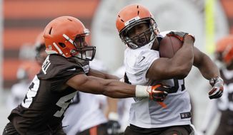 Cleveland Browns running back Nick Chubb, right, tries to avoid defensive back Elijah Campbell during NFL football training camp, Thursday, July 26, 2018, in Berea, Ohio. (AP Photo/Tony Dejak)