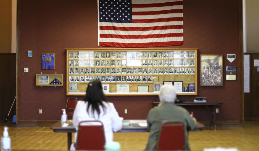 In this June 12, 2018, photo provided by the Wisconsin Center for Investigative Journalism, Julie Routhieaux, administrative specialist for the village of Little Chute, Wis., left, and Patti Seeman, an election inspector, help out with voting at the village hall for a special election in the 1st Senate District. Voting systems in Wisconsin, a key swing state, can be hacked, security experts warn, but local and state officials say not to worry. Wisconsin has seen Russian interference in social media campaigns and attempted hacks of the Democratic Party and government websites. Five election security experts say the state&#x27;s voting system is vulnerable to interference, citing, among other things, hacking demonstrations that show even offline voting machines can be breached. (Coburn Dukehart/Wisconsin Center for Investigative Journalism via AP)