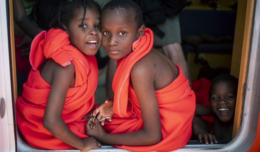 EDS NOTE: SPANISH LAW REQUIRES THAT THE FACES OF MINORS ARE MASKED IN PUBLICATIONS WITHIN SPAIN. In this photo taken on Friday, July 27, 2018, migrant children look at the camera as they travel with others onboard Spain's Concepcion Arenal Maritime Rescue Service boat at the port of Barbate, southern Spain, after being rescued by Spain's Maritime Rescue Service in the Strait of Gibraltar, in Barbate, Spain. Maritime rescue authorities say 751 migrants have been plucked Friday from 52 dinghies trying to reach Spanish shores from northern Africa, this year's most popular route into Europe. (AP Photo/Marcos Moreno)