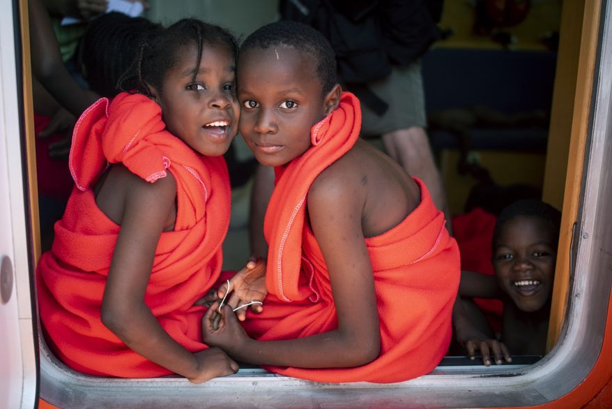 EDS NOTE: SPANISH LAW REQUIRES THAT THE FACES OF MINORS ARE MASKED IN PUBLICATIONS WITHIN SPAIN. In this photo taken on Friday, July 27, 2018, migrant children look at the camera as they travel with others onboard Spain's Concepcion Arenal Maritime Rescue Service boat at the port of Barbate, southern Spain, after being rescued by Spain's Maritime Rescue Service in the Strait of Gibraltar, in Barbate, Spain. Maritime rescue authorities say 751 migrants have been plucked Friday from 52 dinghies trying to reach Spanish shores from northern Africa, this year's most popular route into Europe. (AP Photo/Marcos Moreno)