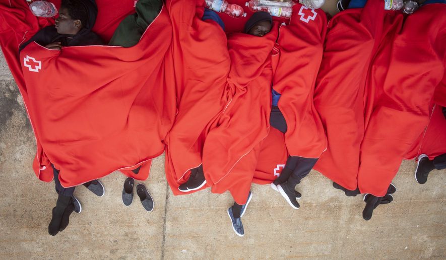 In this photo taken on Friday, July 27, 2018, migrants rest at the port of Tarifa, southern Spain, after being rescued by Spain's Maritime Rescue Service in the Strait of Gibraltar, in Tarifa, Spain. Maritime rescue authorities say 751 migrants have been plucked Friday from 52 dinghies trying to reach Spanish shores from northern Africa, this year's most popular route into Europe. (AP Photo/Marcos Moreno)