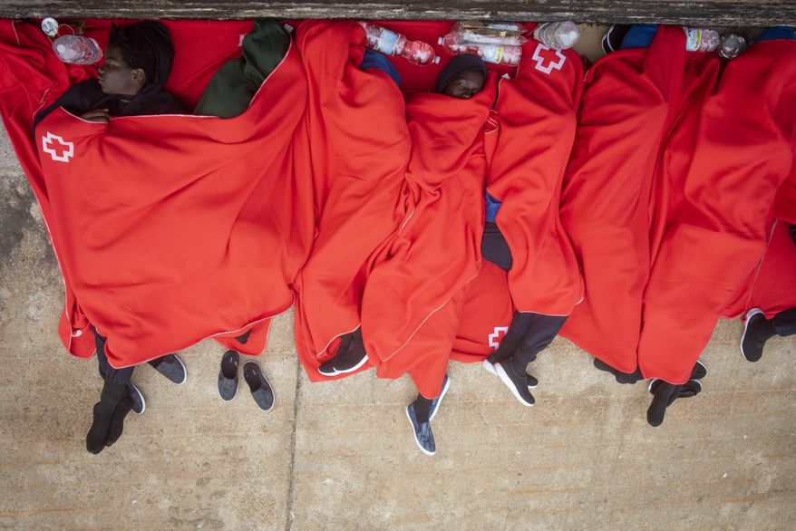 In this photo taken on Friday, July 27, 2018, migrants rest at the port of Tarifa, southern Spain, after being rescued by Spain's Maritime Rescue Service in the Strait of Gibraltar, in Tarifa, Spain. Maritime rescue authorities say 751 migrants have been plucked Friday from 52 dinghies trying to reach Spanish shores from northern Africa, this year's most popular route into Europe. (AP Photo/Marcos Moreno)