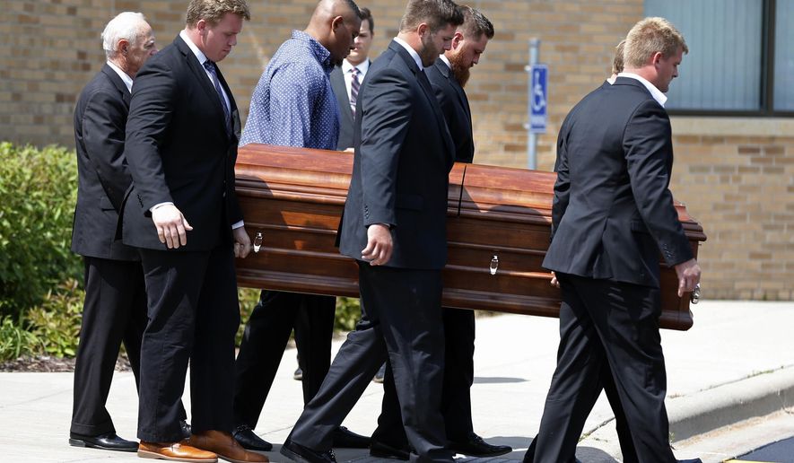 Six Minnesota Vikings offensive linemen serve as pallbearers as they carry the casket of their coach Tony Sparano to a hearse following his funeral at St. Bartholomew Catholic Church Friday, July 27, 2018, in Wayzata, Minn. The 56-year-old NFL football coach died last Sunday of heart disease. (AP Photo/Jim Mone)