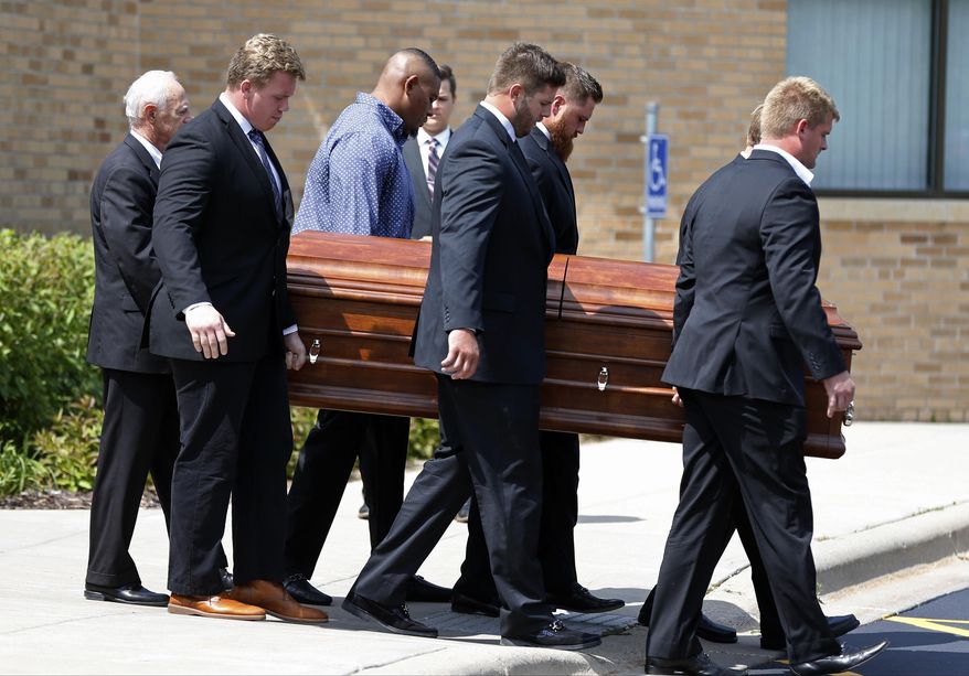 Six Minnesota Vikings offensive linemen serve as pallbearers as they carry the casket of their coach Tony Sparano to a hearse following his funeral at St. Bartholomew Catholic Church Friday, July 27, 2018, in Wayzata, Minn. The 56-year-old NFL football coach died last Sunday of heart disease. (AP Photo/Jim Mone)