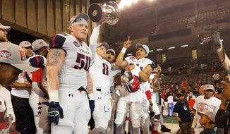 Washington Valor backup quarterback Warren Smith (No. 8) holds the Foster Trophy and celebrates with Jimmy Gordon (No. 50) and other teammates after the Valor beat the Baltimore Brigade 69-55 in ArenaBowl XXXI at Royal Farms Arena in Baltimore on Saturday, July 28, 2018. (Photo by Adam Zielonka/The Washington Times)