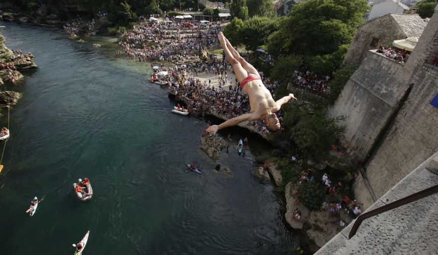 A diver jumps from the Old Mostar Bridge during the 452nd traditional annual high diving competition, in Mostar, Bosnia, 140 kilometers (87 miles) south of the capital Sarajevo, Sunday, July 29, 2018. A total of 40 divers from Bosnia and neighboring countries leapt from the 25-meter-high (82-foot-) bridge into the Neretva River. (AP Photo/Amel Emric)
