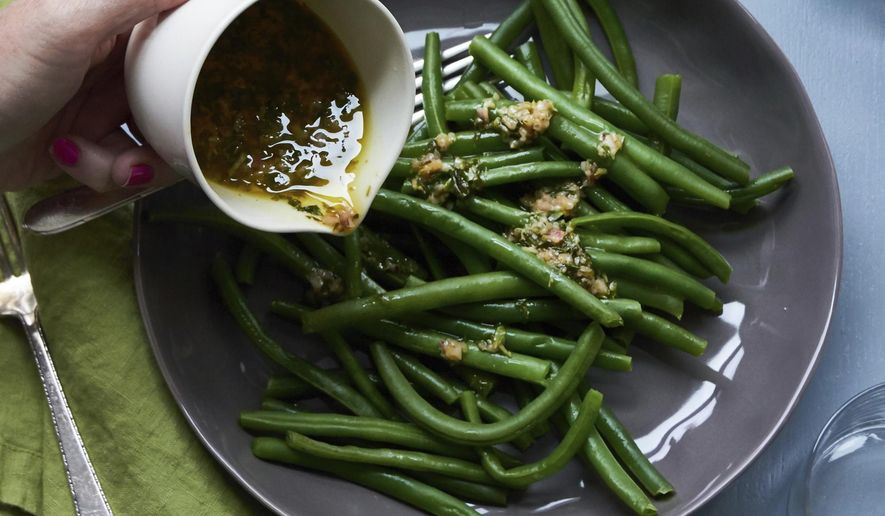 May 2017 photo shows green beans with tarragon dressing in New York. This dish is from a recipe by Katie Workman. (Mia via AP)