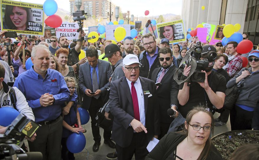 FILE - In this March 30, 2018, photo, Sam Young, center, speaks to a group of people demanding an end to one-on-one interviews between Mormon youth and lay leaders during a march to church headquarters, in Salt Lake City. Young, a Mormon man has launched a hunger strike that started Friday, July 27, 2018, to bring attention to a campaign calling on church leaders to bring an end to closed door, one-on-one interviews between youth and lay leaders where sexual questions sometimes arise. (AP Photo/Rick Bowmer, File)