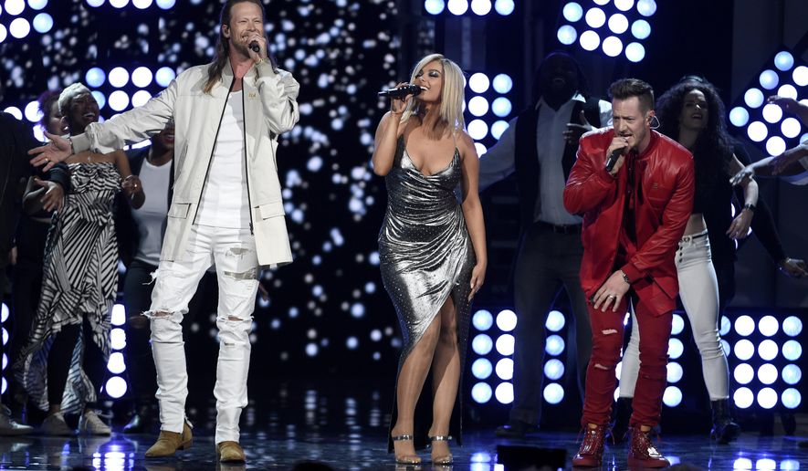 FILE - In this April 15, 2018 file photo, Tyler Hubbard, right, and Brian Kelley, left, of Florida Georgia Line, and Bebe Rexha, center, perform "Meant to Be" at the 53rd annual Academy of Country Music Awards in Las Vegas. The crossover hit “Meant To Be” has broken a new record on the Billboard Hot Country chart, remaining in the No. 1 spot for 35 weeks. (Photo by Chris Pizzello/Invision/AP, File)
