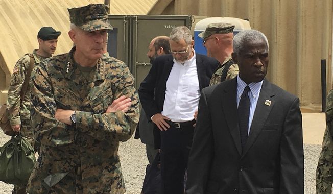 Gen. Thomas D. Waldhauser, left, commander of U.S. Africa Command, is joined by U.S. Ambassador to Senegal Tulinabo S. Mushingi, right, on a tour of a cooperative security location Camp Cisse where the U.S. maintains a small site that allows for U.S. military aircraft to land and refuel, or for storage and use during crisis situations in Dakar, Senegal, Monday, July 30, 2018. The head of the U.S. military in Africa says it has taken steps to increase the security of troops on the ground, adding armed drones and armored vehicles and taking a harder look at when U.S. forces go out with local troops. (AP Photo/Carley Petesch)
