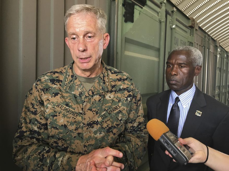 Gen. Thomas D. Waldhauser, left, commander of U.S. Africa Command, is joined by U.S. Ambassador to Senegal Tulinabo S. Mushingi, right, while speaking during a tour of a cooperative security location Camp Cisse where the U.S. maintains a small site that allows for U.S. military aircraft to land and refuel, or for storage and use during crisis situations in Dakar, Senegal, Monday, July 30, 2018. The head of the U.S. military in Africa says it has taken steps to increase the security of troops on the ground, adding armed drones and armored vehicles and taking a harder look at when U.S. forces go out with local troops. (AP Photo/Carley Petesch) **FILE**
