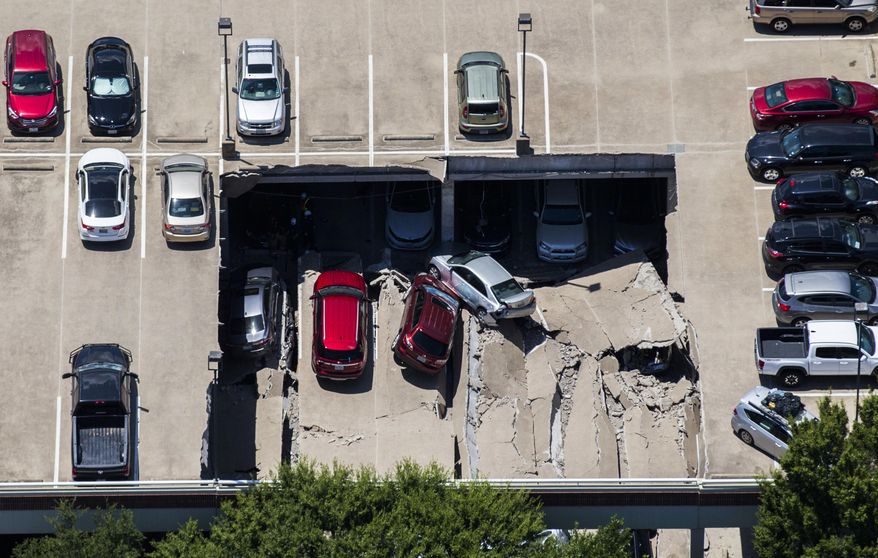 Emergency crews respond to a collapsed parking garage in Irving, Texas, Tuesday, July 31, 2018. A portion of a suburban Dallas parking garage has collapsed, sending vehicles and rubble onto others below, but authorities say there are no apparent injuries. (Ashley Landis/The Dallas Morning News via AP)