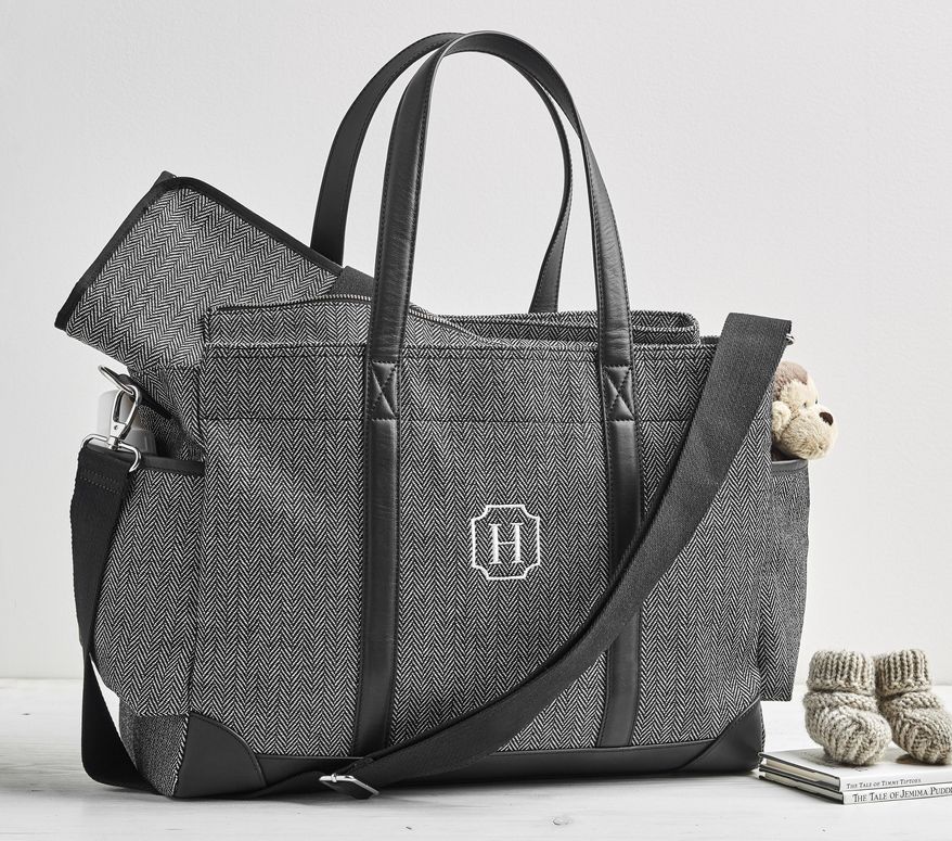 This undated photo provided by Potter Barn Kids shows one of their designer diaper bags with herringbone. Diaper bags today are far more style-savvy than in the past. Tailored patterns like houndstooth and herringbone, leather or vegan leather trims, and smart hardware all give trendy baby gear panache along with purpose. (Pottery Barn Kids via AP)