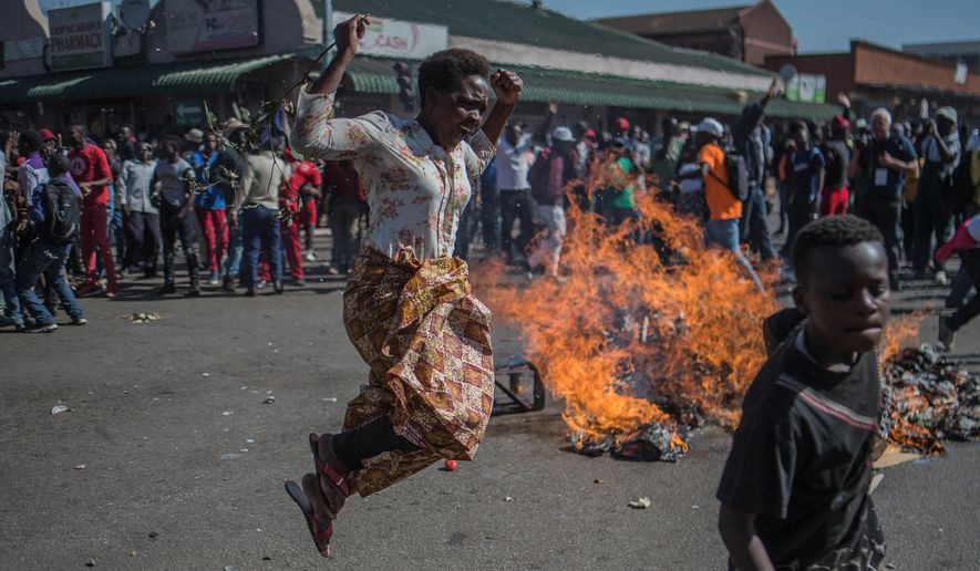 Opposition MDC party supporters protested in the streets of Harare during clashes with police Wednesday. Hundreds of angry opposition supporters outside the Zimbabwe Electoral Commission were met by riot police firing tear gas and live ammunition. (Associated Press)