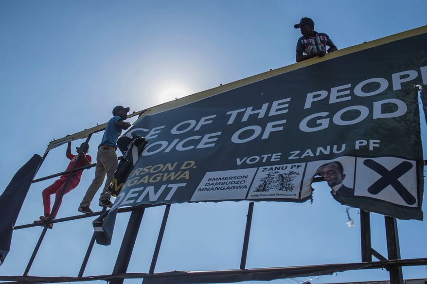 Opposition MDC party supporters ripped down a banner of the ruling ZANU-PF party on a street in Harare on Wednesday. (Associated Press)