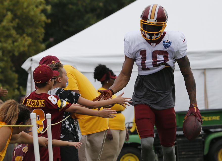 Washington Redskins wide receiver Josh Doctson slaps hands with fans during the morning session at NFL football training camp in Richmond, Va., Wednesday, Aug. 1, 2018. (AP Photo/Steve Helber)