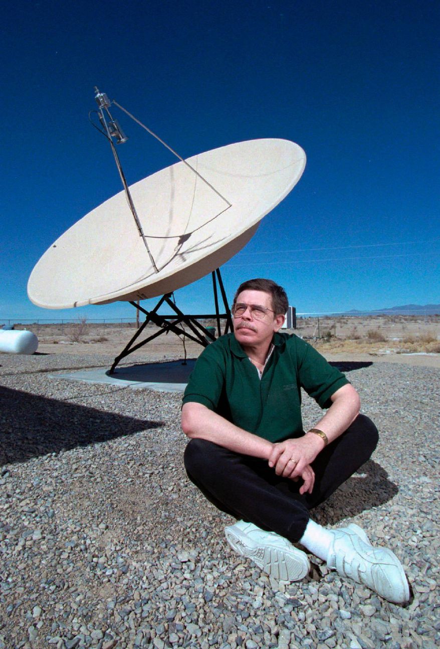 FILE - In this March 7, 1997, file photo, late night talk show host Art Bell sits near a satellite dish at his home in Pahrump, Nev. Authorities in Nevada say Bell, a syndicated radio host best known for nightly shows in the 1990s about paranormal themes and conspiracy theories, died of an accidental overdose of prescription drugs. Nye County Sheriff Sharon Wehrly posted a brief Facebook announcement Wednesday, Aug. 1, 2018, saying that an autopsy determined the 72-year-old Bell died April 13 at home in Pahrump of "multiple drug intoxication from his own lawfully prescribed prescriptions." (Aaron Mayes/Las Vegas Sun via AP, File)