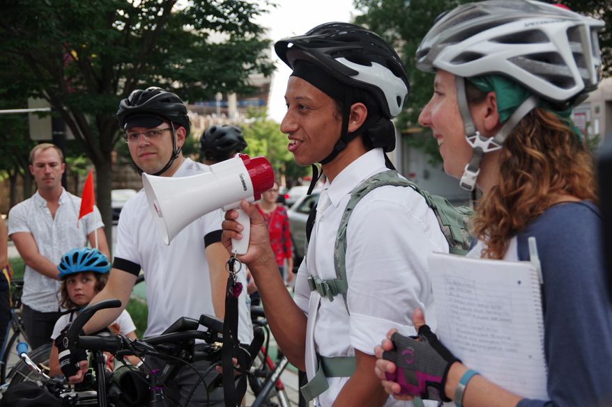 Cyrus Habib (center) speaks to a crowd of 50 cyclists on Tuesday before leading a memorial procession for his brother who was killed while riding his bike last month. Rachel Maisler (right), of the D.C. Bicycle Advisory Council, planned the ride. (Julia Airey/The Washington Times)