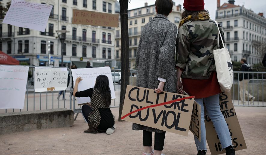 FILE - In this Oct. 29, 2017 file photo, a woman holds a banner that reads: 'Rape Culture' during a demonstration in Lyon, central France, to support the wave of testimonies denouncing cases of sexual harassment. French lawmakers have voted Wednesday Aug. 1, 2018 to expand the definition of child rape and to outlaw sex harassment on the street. (AP Photo/Laurent Cipriani, File)