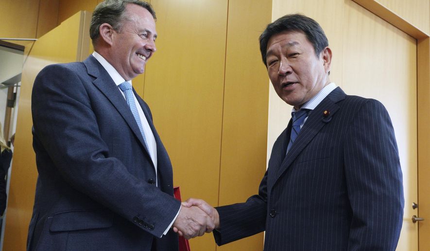 In this Tuesday, July 31, 2018, photo, Britain's Secretary of State for International Trade Liam Fox, left, shakes hands with Japanese Minister of Economic Revitalization Toshimitsu Motegi during their meeting in Tokyo. Fox said Wednesday, Aug. 1, 2018, the United Kingdom wants to align itself with Asia’s growing economies as it prepares to leave the European Union. Fox said that he welcomed the support he received from Japanese leaders for Britain’s aspirations to join an 11-country Pacific trade agreement. He is on the last day of a three-day trip to Japan after visiting the United States. (AP Photo/Eugene Hoshiko)