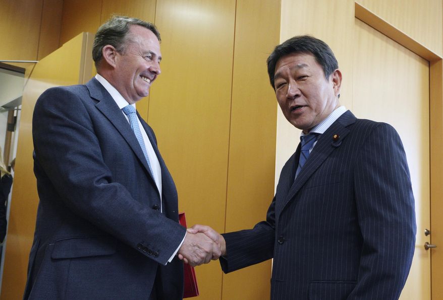 In this Tuesday, July 31, 2018, photo, Britain's Secretary of State for International Trade Liam Fox, left, shakes hands with Japanese Minister of Economic Revitalization Toshimitsu Motegi during their meeting in Tokyo. Fox said Wednesday, Aug. 1, 2018, the United Kingdom wants to align itself with Asia’s growing economies as it prepares to leave the European Union. Fox said that he welcomed the support he received from Japanese leaders for Britain’s aspirations to join an 11-country Pacific trade agreement. He is on the last day of a three-day trip to Japan after visiting the United States. (AP Photo/Eugene Hoshiko)