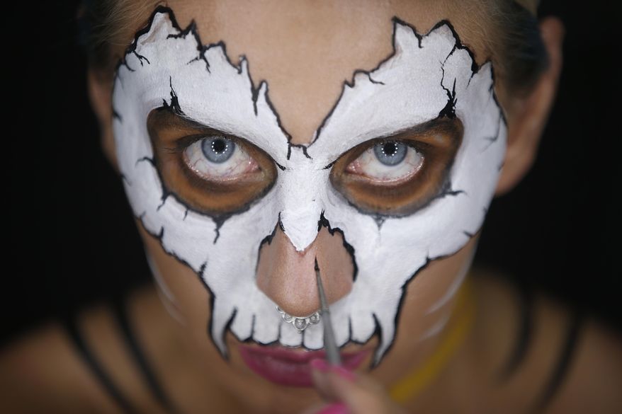In this Friday, July 27, 2018 photo, Serbian make-up artist Mirjana Milosevic known professionally as 'Kika' paints her face in her studio at her home in the central Serbian town of Smederevo, Serbia. Milosevic has won international recognition for the skin illusions that she applies on her own body, later posting the whole process on her You Tube channel and social networks. (AP Photo/Darko Vojinovic)