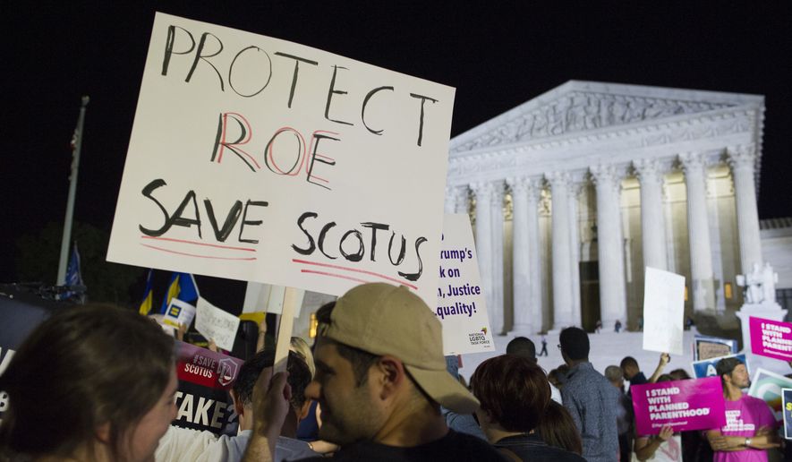 In this July 9, 2018, file photo, demonstrators holds signs as they gather in front of the Supreme Court in Washington after President Donald Trump announced Judge Brett M. Kavanaugh as his Supreme Court nominee. Worried by the prospect of a reconfigured court, abortion-rights advocates are intensifying efforts to ensure access to abortion for women who might be affected by a new wave of bans and restrictions. (AP Photo/Cliff Owen, File)