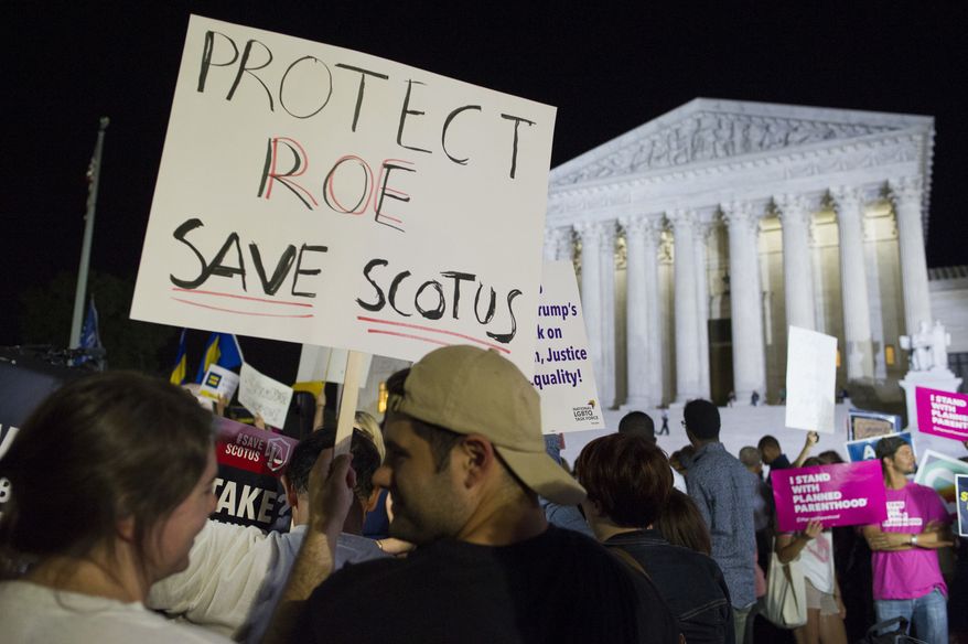In this July 9, 2018, file photo, demonstrators holds signs as they gather in front of the Supreme Court in Washington after President Donald Trump announced Judge Brett M. Kavanaugh as his Supreme Court nominee. Worried by the prospect of a reconfigured court, abortion-rights advocates are intensifying efforts to ensure access to abortion for women who might be affected by a new wave of bans and restrictions. (AP Photo/Cliff Owen, File)