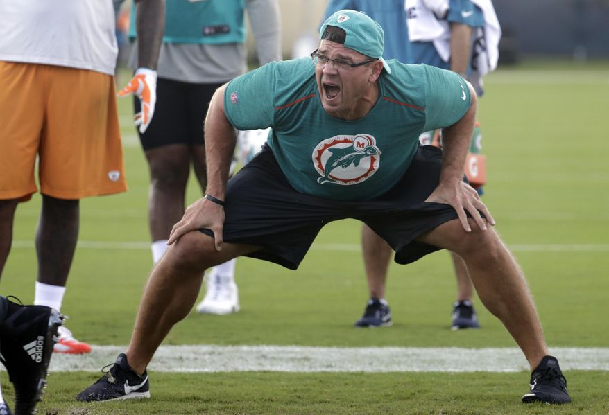 In this Wednesday, Aug. 1, 2018, photo, Miami Dolphins defensive line coach Kris Kocurek shouts as players do drills at the NFL football team's training camp, in Davie, Fla. Holler guy Kris Kocurek is the Miami Dolphins' new defensive line coach, which puts him in charge of a unit that underachieved last year and is adjusting to the departure of Pro Bowl tackle Ndamukong Suh.(AP Photo/Lynne Sladky)