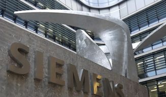 FILE - In this Thursday, Nov. 9, 2017 file photo, the logo of German industrial conglomerate Siemens in front of the headquarters in Munich, Germany. German industrial conglomerate Siemens reports its third quarter earnings on Thursday, Aug. 2, 2018. (AP Photo/Matthias Schrader, File)