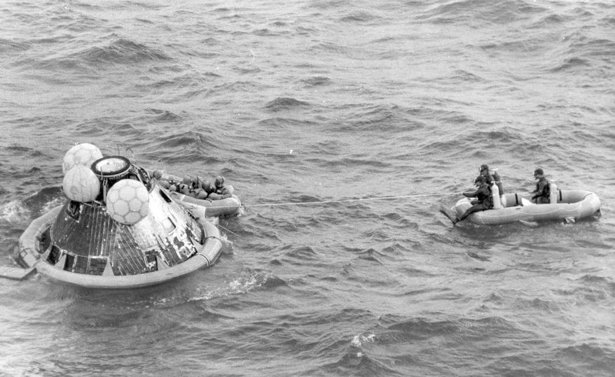 FILE - In this July 24, 1969, file photo, the Apollo 11 command module lands in the Pacific Ocean and the crew waits to be picked up by U.S. Navy personnel after an eight day mission to the moon. A solid-gold replica of the Apollo 11 lunar module stolen in July 2017 from an Ohio museum honoring the late astronaut Neil Armstrong has yet to be recovered, a year later. (AP Photo/File)