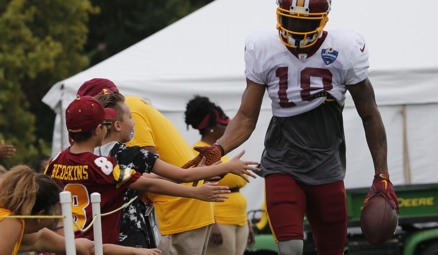 Washington Redskins wide receiver Josh Doctson slaps hands with fans during the morning session at NFL football training camp in Richmond, Va., Wednesday, Aug. 1, 2018. (AP Photo/Steve Helber)
