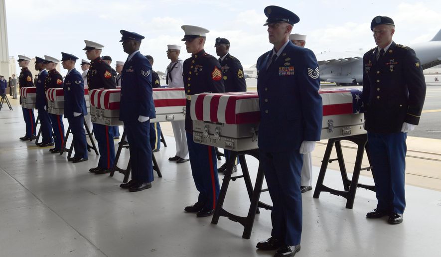 Military members stand at attention after placing transfer cases in a hanger at a ceremony marking the arrival of the remains believed to be of American service members who fell in the Korean War at Joint Base Pearl Harbor-Hickam in Hawaii, Wednesday, Aug. 1, 2018. North Korea handed over the remains last week. (AP Photo/Susan Walsh)