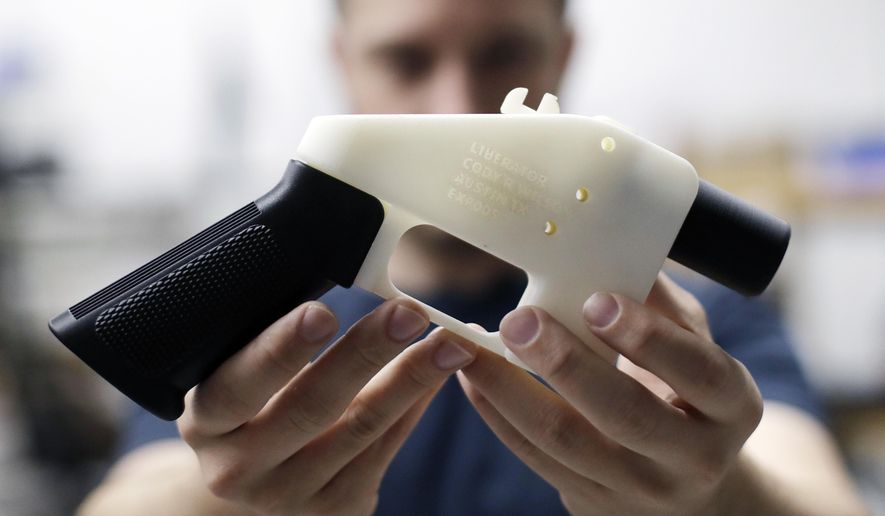 FILE--In this Aug. 1, 2018, file photo, Cody Wilson, with Defense Distributed, holds a 3D-printed gun called the Liberator at his shop in Austin, Texas. Eleven states have joined eight others and the District of Columbia in a federal lawsuit that seeks to block a settlement the Trump administration reached with a company that wants to post online plans to make 3D firearms on a printer. (AP Photo/Eric Gay)