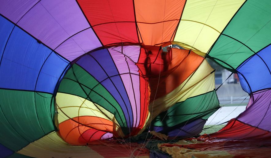 Brian Kunze checks his balloon before the hot air balloon race at the Indiana State Fair, Friday, Aug. 3, 2018, in Indianapolis. The fair runs through, Sunday, Aug. 19th. (AP Photo/Darron Cummings)