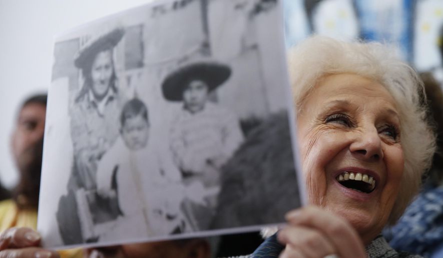 President of the Grandmothers of Plaza de Mayo human rights group, Estela de Carlotto, holds a photo of Rosario del Carmen Ramos, with two of her three sons Ismael, right, and Camilo, before she disappeared during Argentina's military dictatorship, in Buenos Aires, Argentina Friday, Aug. 3, 2018. The human rights group announced they found Rosario's other son Marcos Eduardo Ramos, who was kidnapped together with his brother Ismael in 1976 during the last military dictatorship in Argentina. (AP Photo/Natacha Pisarenko)