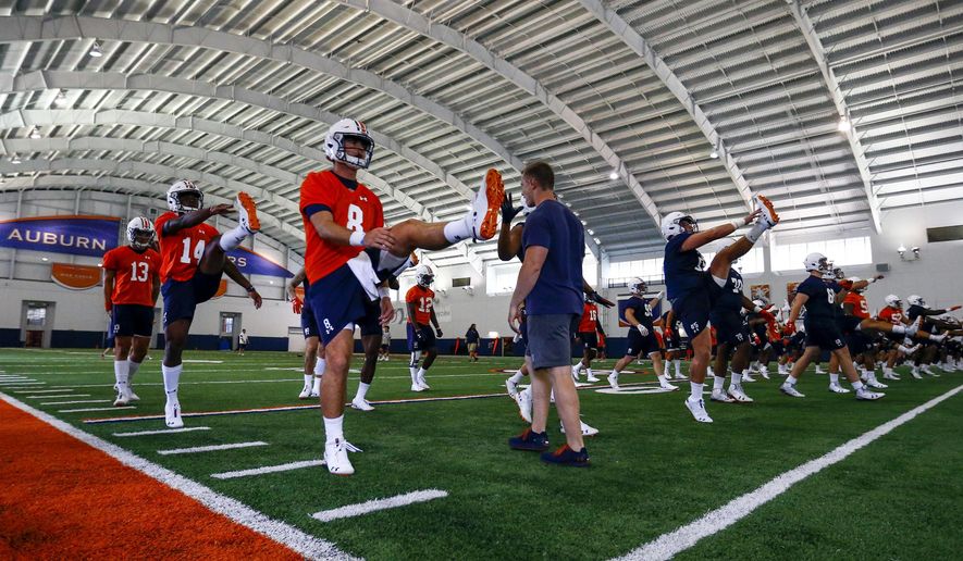 Auburn quarterback Jarrett Stidham (8) stretches with fellow players during NCAA college football practice, Friday, Aug. 3, 2018, in Auburn, Ala. (AP Photo/Butch Dill)
