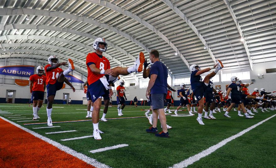 Auburn quarterback Jarrett Stidham (8) stretches with fellow players during NCAA college football practice, Friday, Aug. 3, 2018, in Auburn, Ala. (AP Photo/Butch Dill)